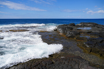 Waves crashing on the lava rocks of South Point Park, the southernmost point of the United States on the Big Island of Hawaii in the Pacific Ocean