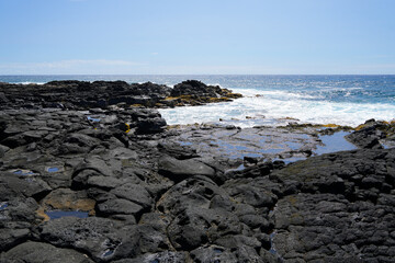Waves crashing on the lava rocks of South Point Park, the southernmost point of the United States on the Big Island of Hawaii in the Pacific Ocean