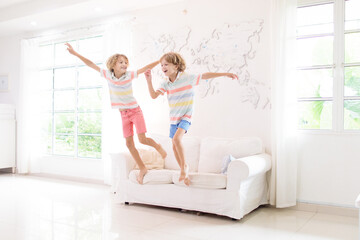 Fototapeta na wymiar Kids play at home. Children jump, run and dance