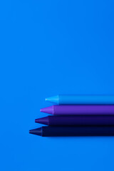 top view of blue gradient crayons on bright background.