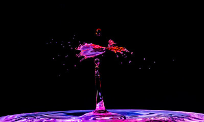 As red water was dropped into blue water, they mixed and splashed to create a shape that looks like a purple dancer, flying through the air.