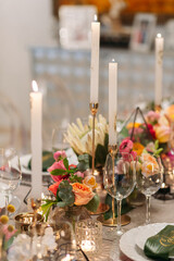 Wedding banquet. Table setting. Banquet tables are decorated with compositions of yellow flowers and protea, ranunculus on the tables are plates with napkins, glasses, candles and cutlery