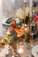 Wedding banquet. Table setting. Banquet tables are decorated with compositions of yellow flowers and protea, ranunculus on the tables are plates with napkins, glasses, candles and cutlery