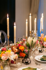 Wedding banquet. Table setting. Banquet tables are decorated with compositions of yellow flowers and protea, ranunculus on the tables are plates with napkins, glasses, candles and cutlery