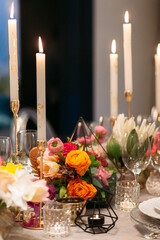 Wedding banquet. Table setting. Banquet tables are decorated with compositions of yellow flowers and protea, ranunculus on the tables are plates with napkins, glasses, candles and cutlery