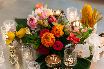 Wedding banquet. Table setting. Banquet tables are decorated with compositions of yellow flowers and protea, ranunculus on the tables are plates with napkins, glasses, candles and cutlery
