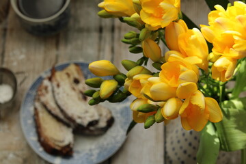 Yellow freesias and homemade slices cake. Romantic coffee time . Selective focus . Still life food stile 