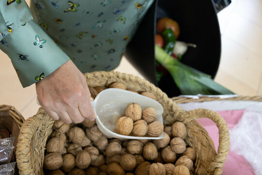 Caucasian customer picking some walnuts as an ingredient to buy to cook a cake