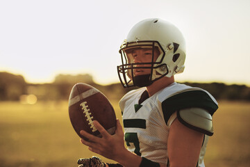 Quarterback standing with a football on a sports field