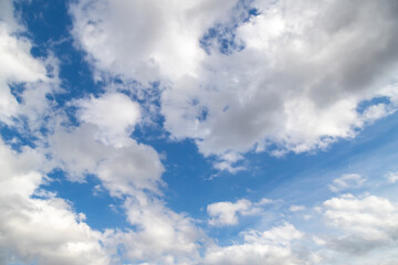 White cumulus clouds on a clear blue sky.