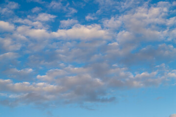 White cumulus clouds on a clear blue sky.