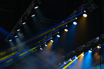 Professional stage lights at the concert stage in yellow and blue colours