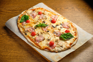 Pizza with bacon and ham and tomatoes