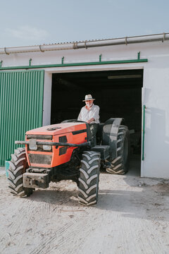 Farmer driving out of garage in tractor