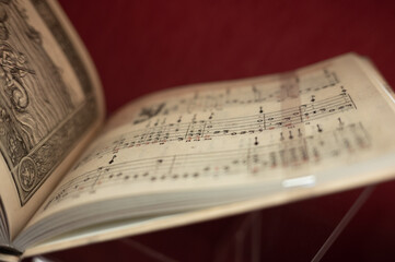 An open vintage music book with a narrow focus directed to the center