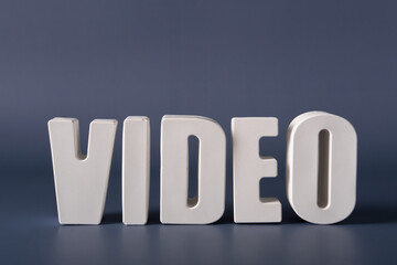 Word Video made from white concrete letters on the blue background
