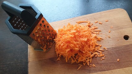 Grated carrots and grater on the kitchen table