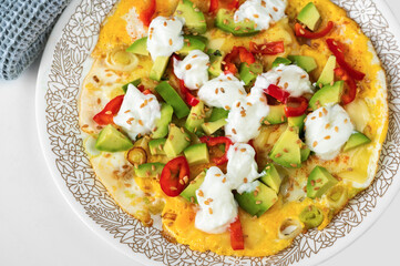 Egg omelette with avocado, pepper, onion, linseed and yoghurt.