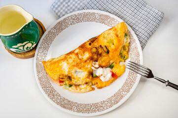 Egg omelette with vegetable, green pitcher, towel.