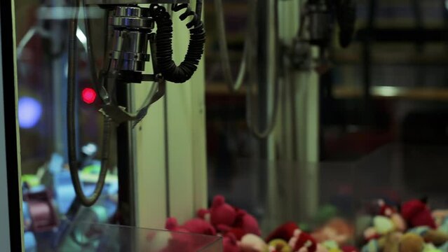 Crane Toy Grabbing Machine, Claw Crane Machine Grabbing a Toy. Close Up. 4K Resolution.