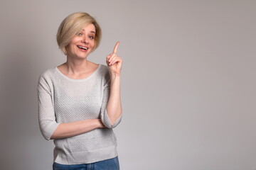 Inspiration, Creativity, Solution, Eureka concept. Portrait of excited young woman raising finger up and smiling, having wow creative idea, copy space