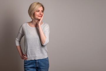 Portrait of a young woman looking astonished at the results, on gray background. Cool Offer. Surprised younglady pointing at free space .Excited shocked