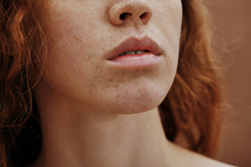Close-up of beautiful young woman face with freckles and no-makeup