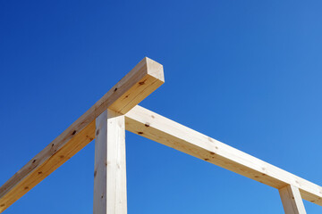 Wooden beams of construction structure, on background of blue sky 