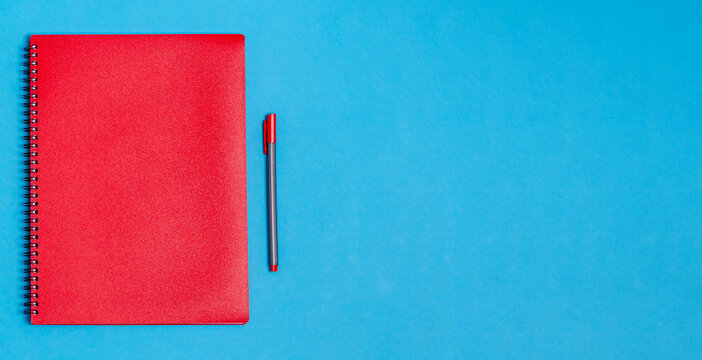 Notebook with a pen on a blue background.