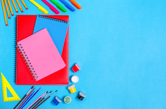 Notebooks with stationery accessories on a blue background.