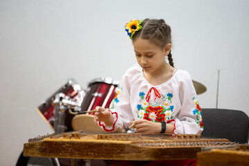 The girl plays the ethnic instrument dulcimer