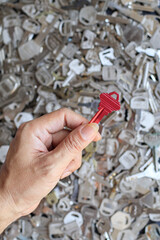The locksmith holds the house keys in his hand to copy the new keys to the customer according to...