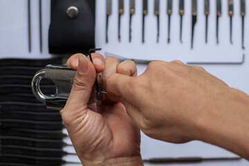 Many key picks in locksmith's hand are tools that require skill and practice to work in picking or unlocking locked key with an available key picker.concept of practice using locksmith tools to unlock