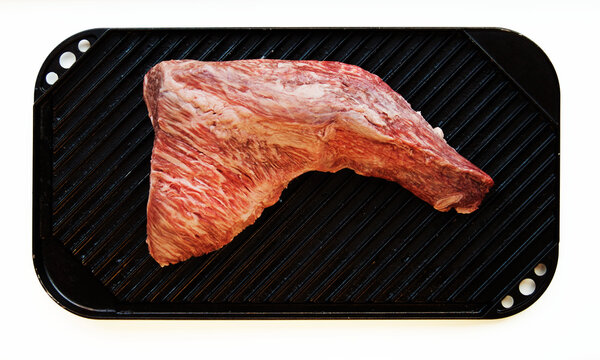 Raw tri-tip steak on grilling pan 
