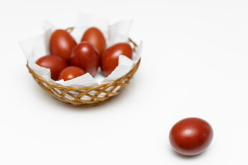a red easter egg lies on the background of a basket with eggs