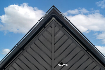 A modern graphite herringbone roof lining is attached to the trusses, visible cables and holes for...