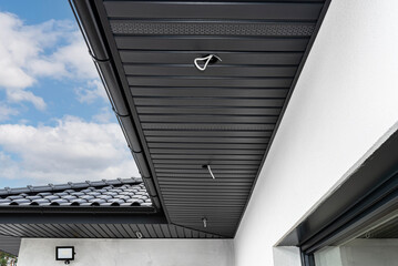 A modern graphite roof lining is attached to the trusses, visible cables and holes for LED lights. © Michal