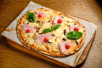 Pizza with bacon and ham and tomatoes