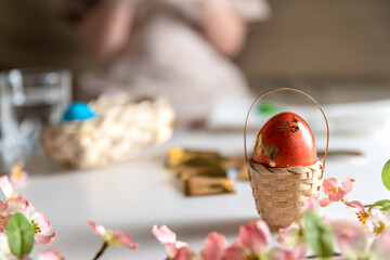 girl at home in the kitchen dyes eggs for Easter