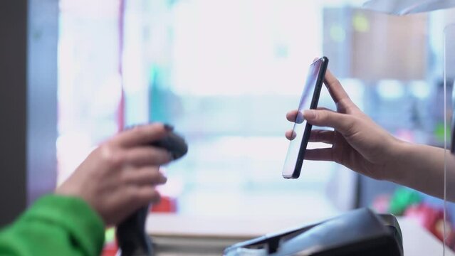 The cashier scans the smartphone screen. Purchase or bonus system 