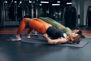 Pretty women working out in a gym. Adult ladies with beautiful shaped bodies.