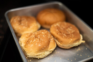 Four Hamburger Buns in a tin tray