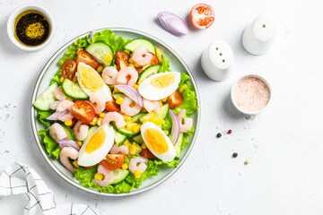Healthy low carb shrimp egg salad on plate on light background. Top view, copy space.