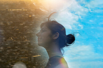女性の横顔と都市と空の合成写真