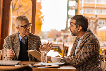 Discussing the documetns on the tablet while looking at them and sitting