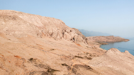Fototapeta na wymiar Rocky desert landscape with ocean sea and blue sky in summer