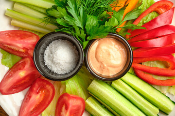 Fresh vegetables (cucumbers, tomatoes, dill, shallots) on a white plate