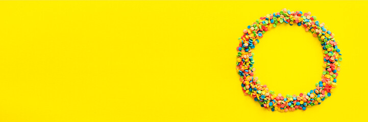 A multicolored circle on a yellow background.