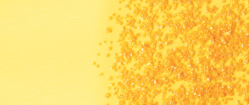 Colorful candies are neatly scattered on a yellow background