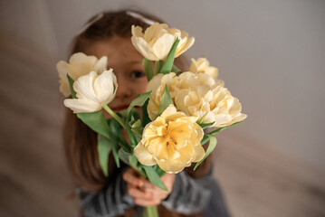 bouquet of yellow tulips the girl is holding in her hands